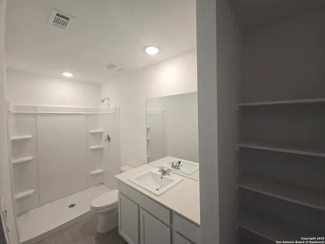 a bathroom with a sink a toilet and shower