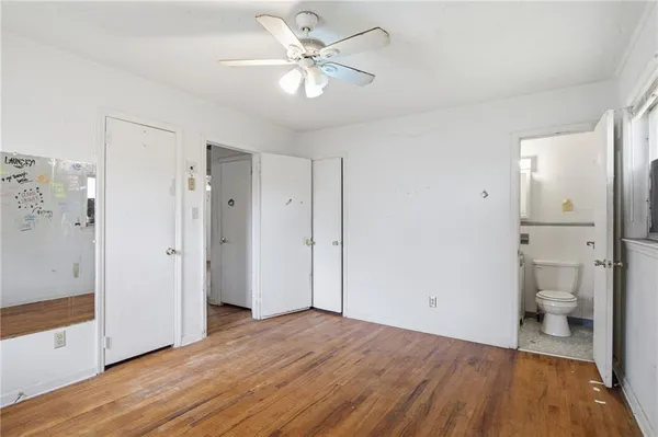 a view of a bathroom with a hardwood floor and a ceiling fan