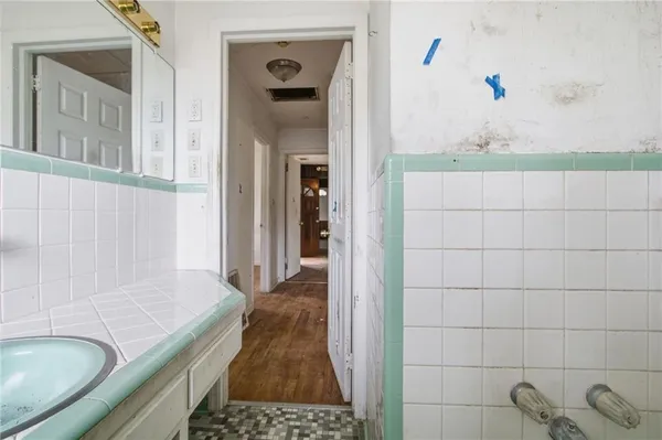 a bathroom with a granite countertop sink a mirror and shower