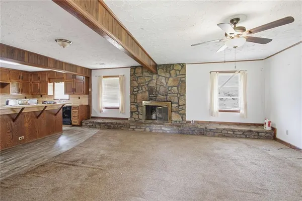 a view of an empty room with a fireplace and a window