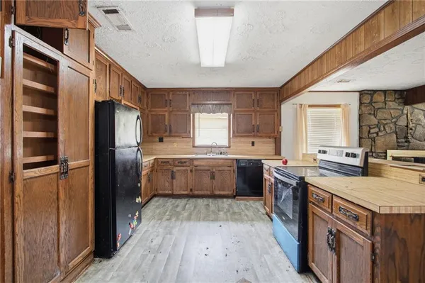 a kitchen with a stove a refrigerator and a sink