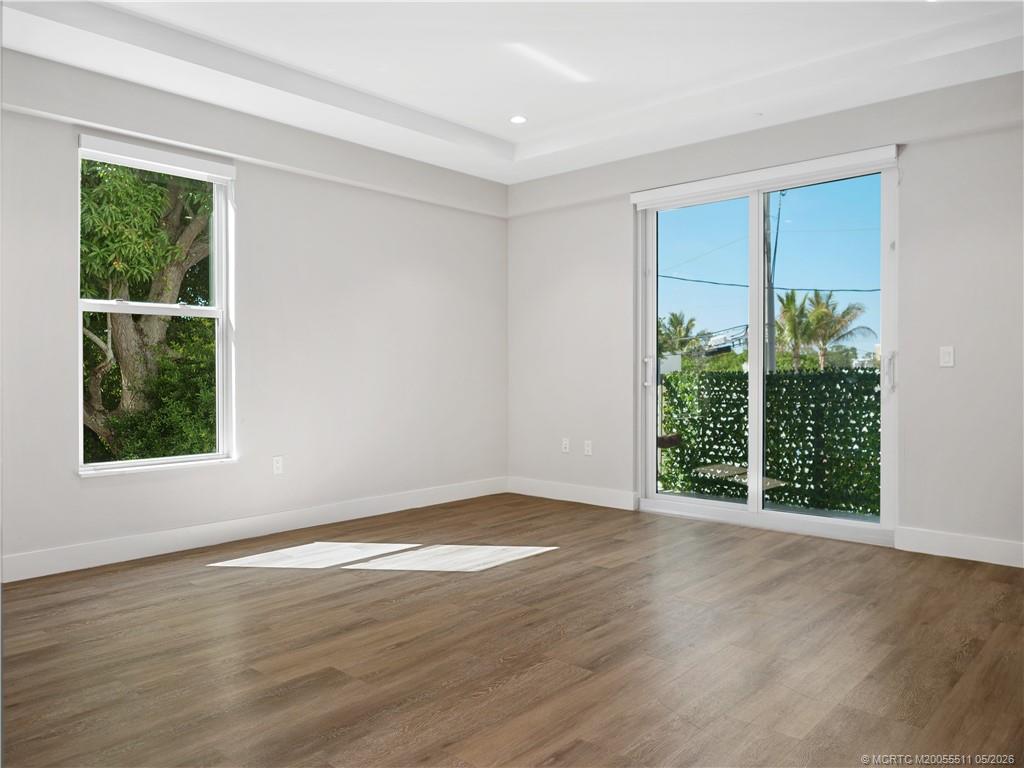 41 Southwest Seminole Street, Unit 208 Stuart, FL 34994 - Photo 21 of 46 a view of an empty room with wooden floor and a window