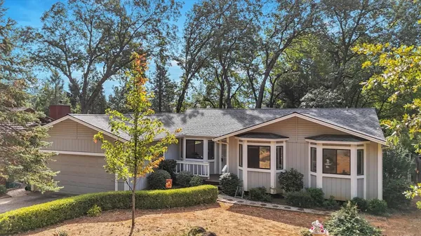 a front view of a house with a yard and potted plants