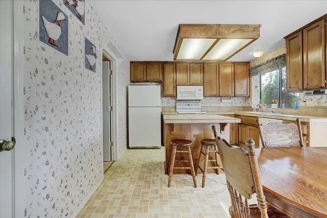 a kitchen with a stove a sink cabinets and a refrigerator