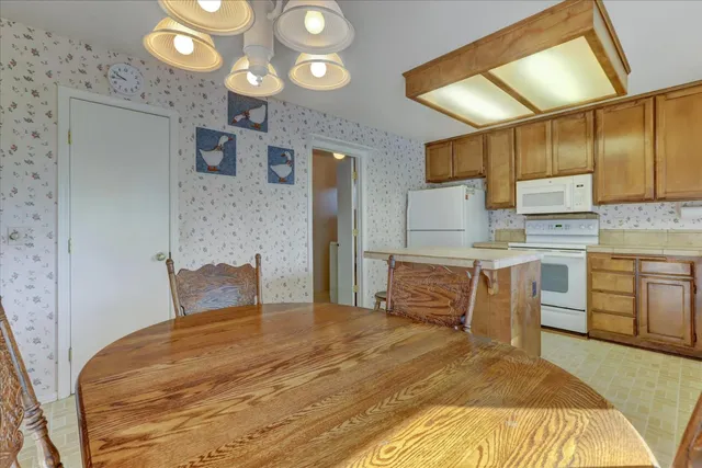 a kitchen with a table chairs refrigerator and sink