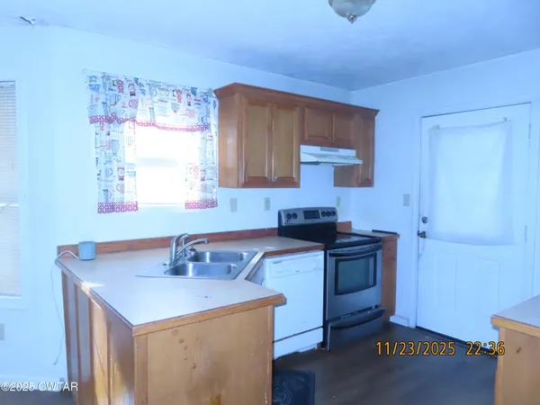 a kitchen with a sink cabinets and wooden floor