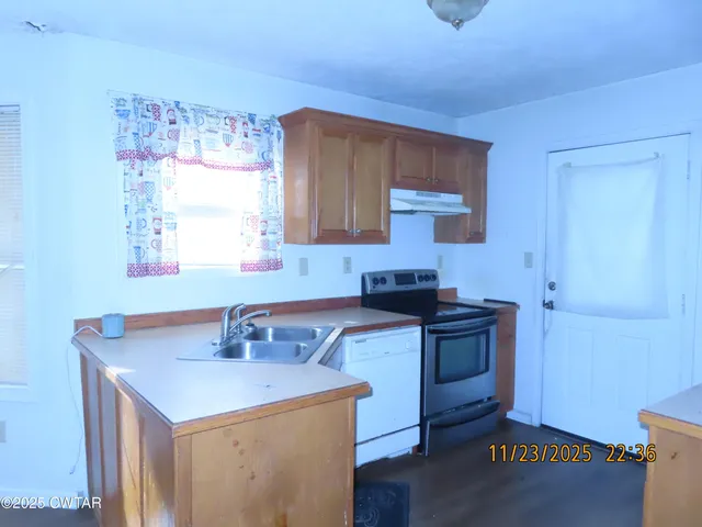 a kitchen with a sink cabinets and wooden floor