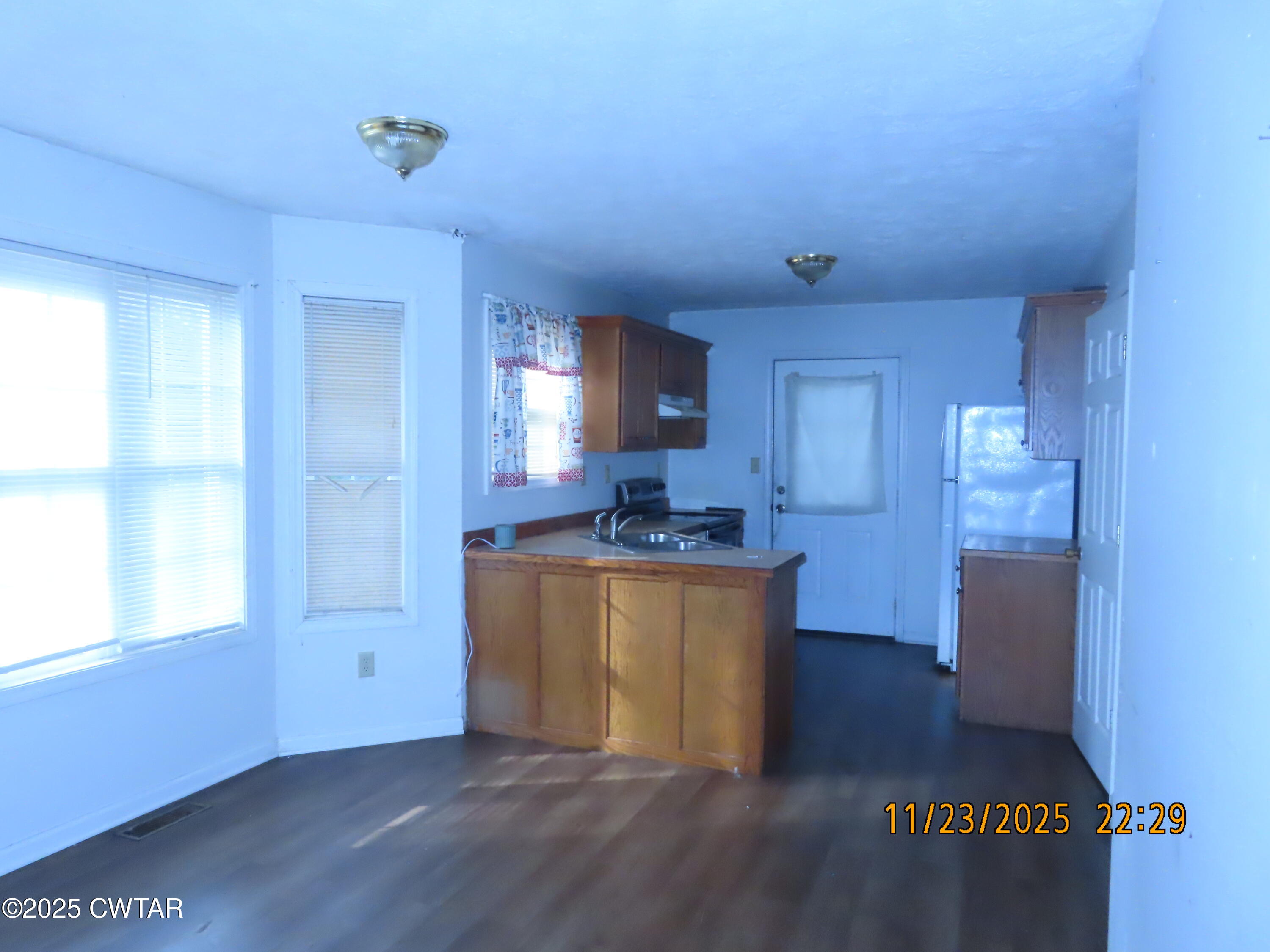 111 Rhea Street Jackson, TN 38301 - Photo 8 of 24 a kitchen with stainless steel appliances granite countertop a stove a sink and a refrigerator with wooden floor