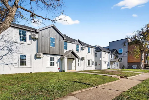 a view of a big house with a big yard and large tree
