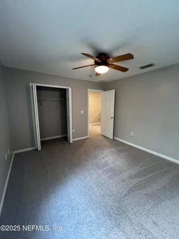 a view of a big room with closet and windows