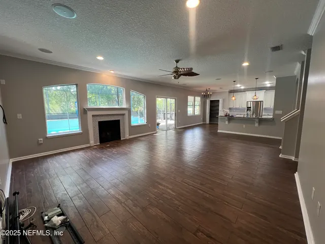 a kitchen with granite countertop a refrigerator and a stove top oven