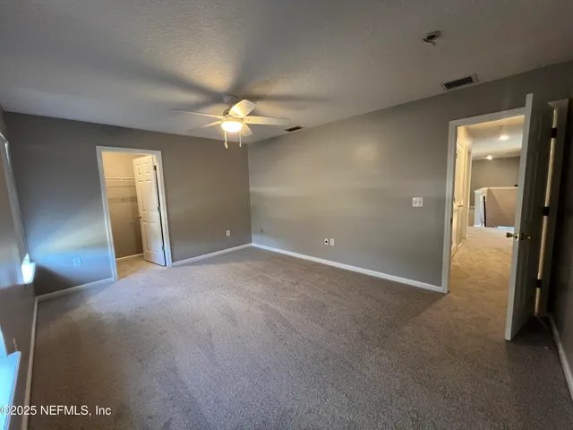 an empty room with fan and entrance