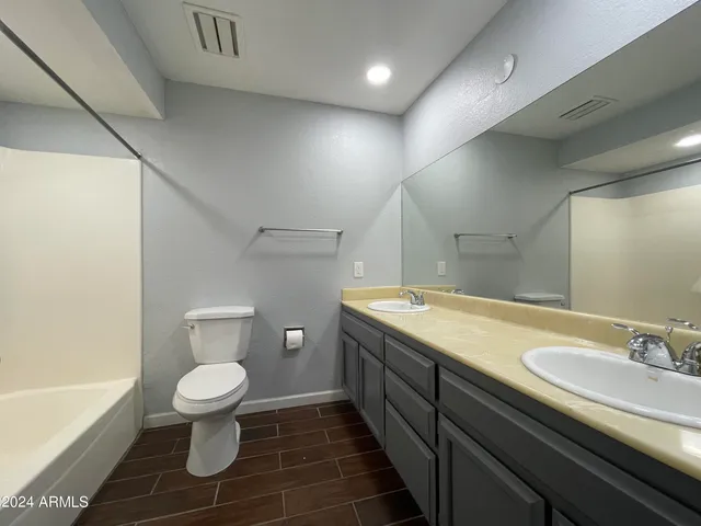 a bathroom with a granite countertop sink a toilet and a bathtub