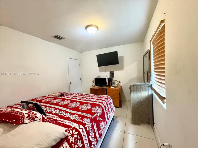 a bedroom with a bed and a television