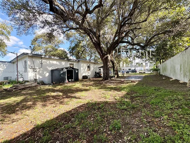 a view of a yard with large trees