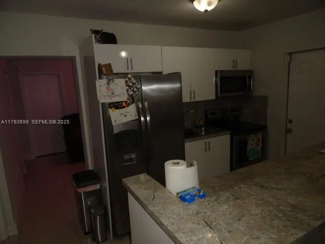 a kitchen with refrigerator and window