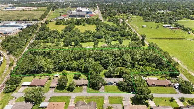 an aerial view of residential houses with outdoor space and trees