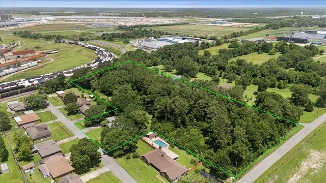 an aerial view of ocean and residential houses with outdoor space