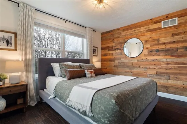 a bedroom with a bed and a wall painting