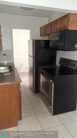a kitchen with granite countertop a stove and a refrigerator