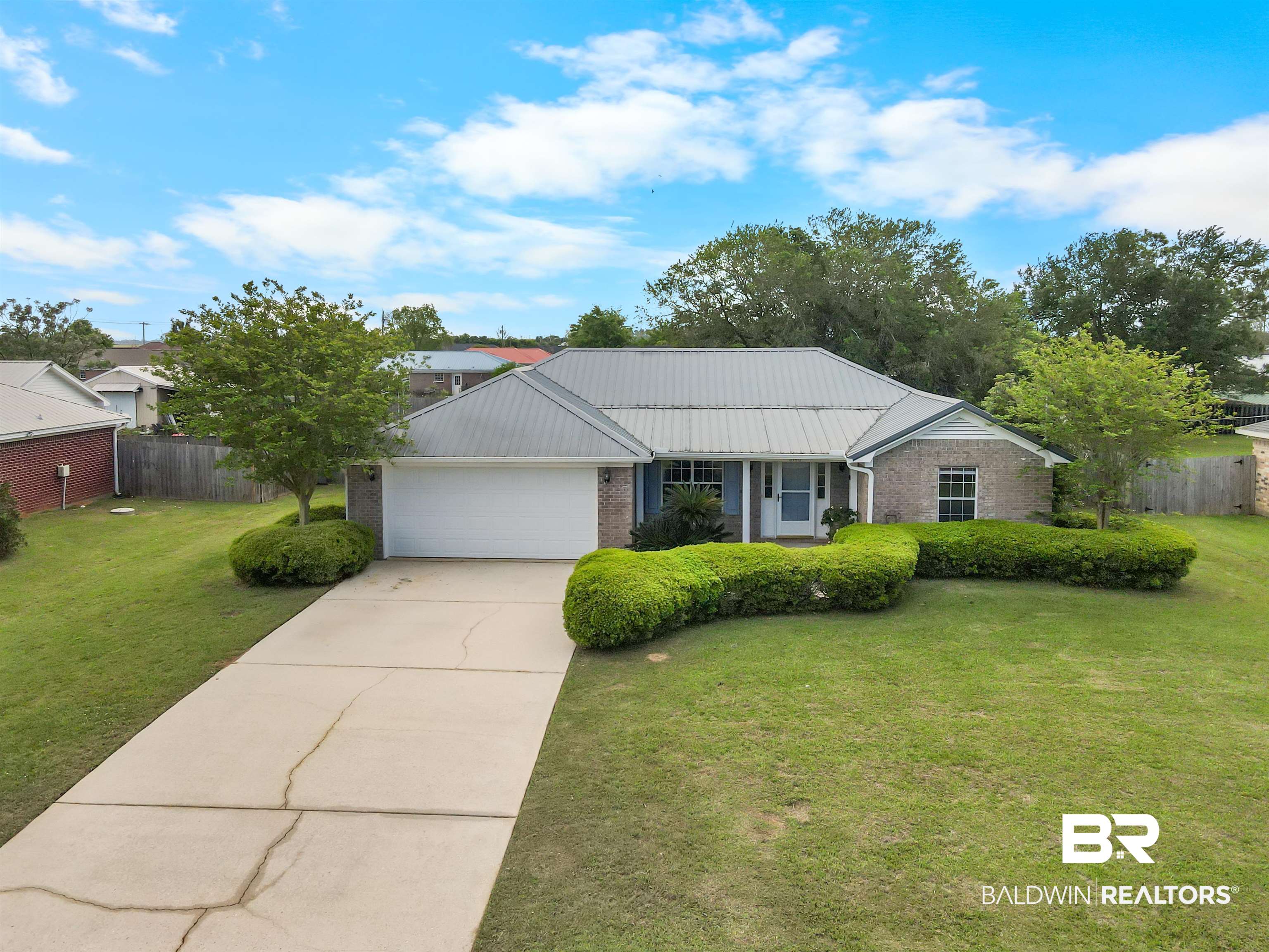 8940 Caitlin Street Foley, AL 36535 - Photo 18 of 27 Ranch-style house with brick siding, concrete driveway, an attached garage, and a standing seam roof