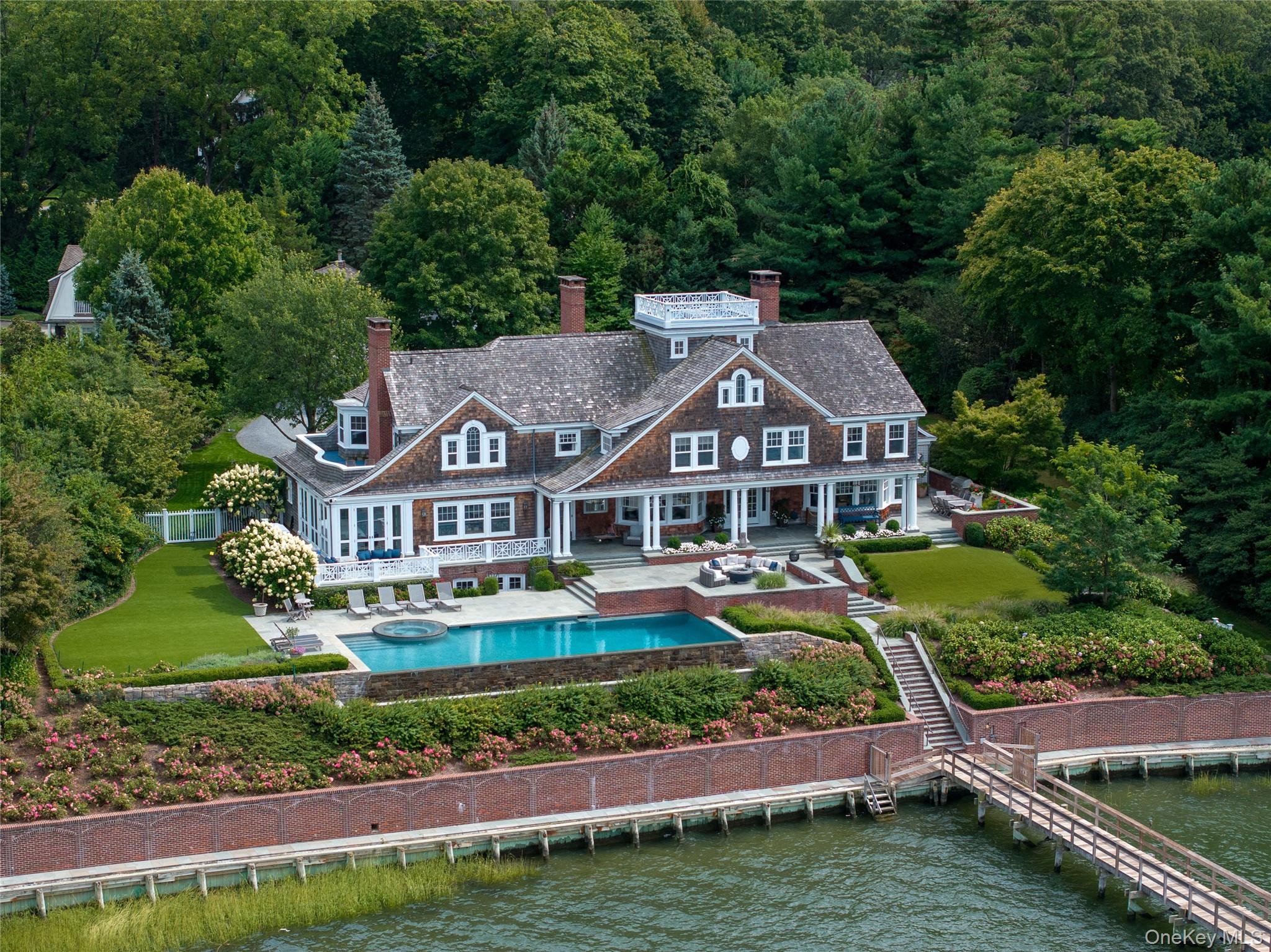 75 Cove Neck Road Cove Neck, NY 11771 - Photo 1 of 40 an aerial view of a house with a garden and lake view