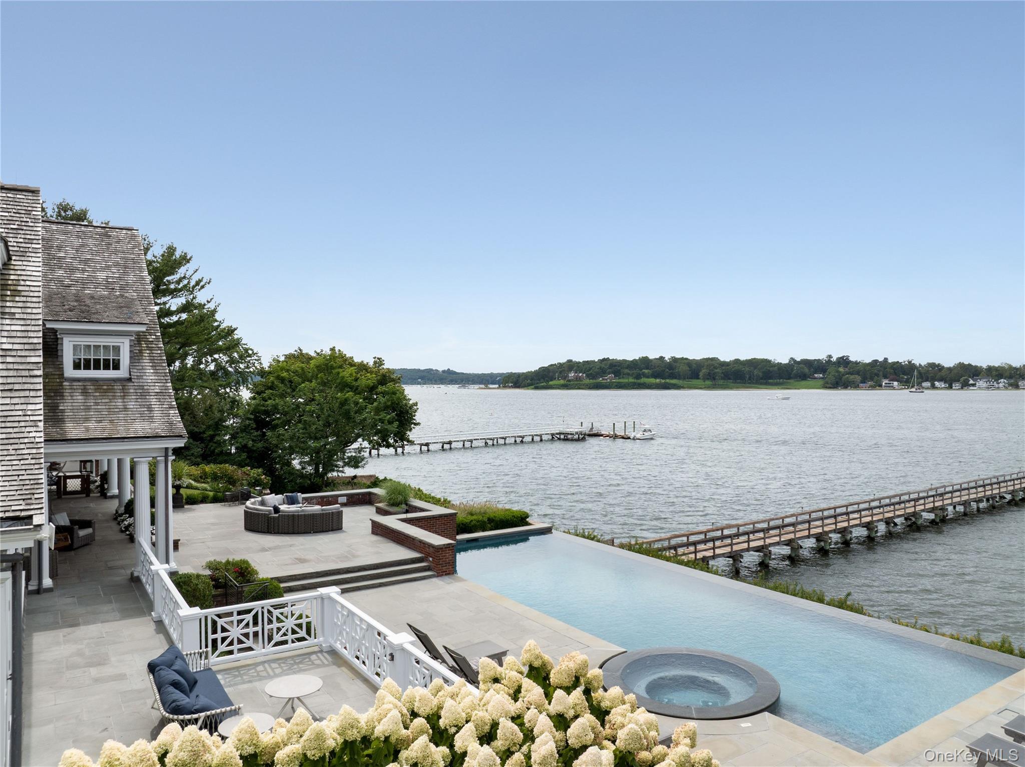 75 Cove Neck Road Cove Neck, NY 11771 - Photo 6 of 40 a view of a lake with couches and city view