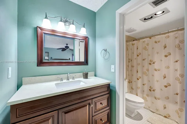 a bathroom with a sink a toilet and shower curtain