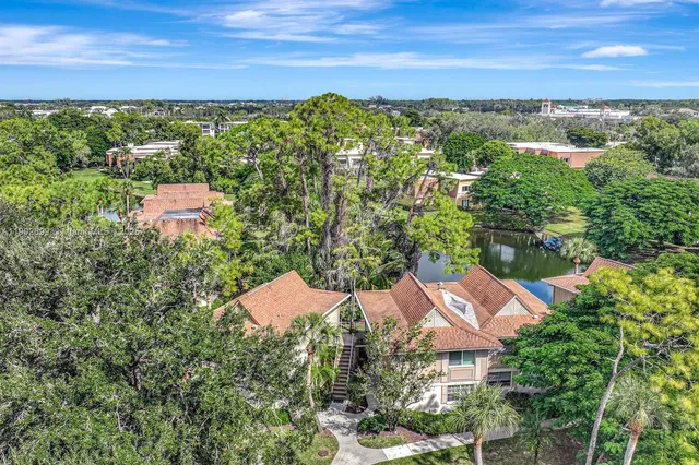 an aerial view of residential houses with outdoor space and trees