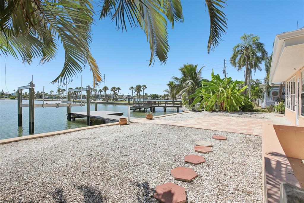 16016 4th Street East Redington Beach, FL 33708 - Photo 25 of 29 a row of palm trees and swimming pool in the backyard of a house