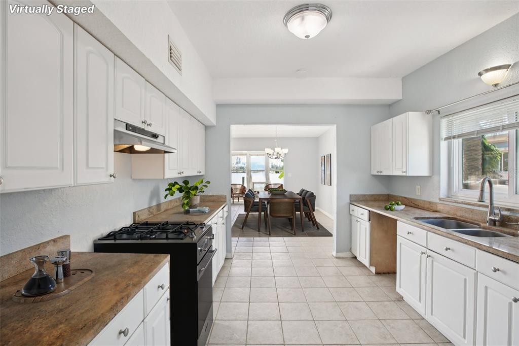 16016 4th Street East Redington Beach, FL 33708 - Photo 7 of 29 a kitchen with a stove a sink a refrigerator and cabinets