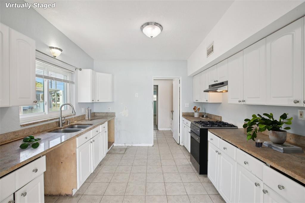 16016 4th Street East Redington Beach, FL 33708 - Photo 9 of 29 a kitchen with a sink stove and cabinets