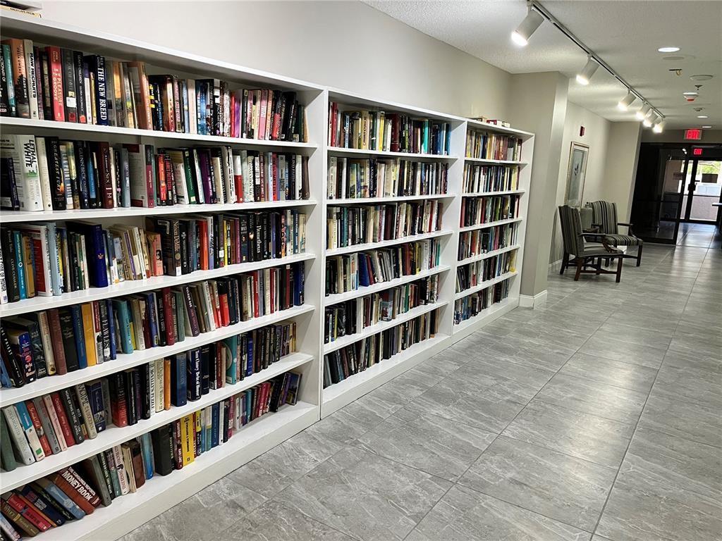 10100 Northwest 30th Court, Unit 310 Sunrise, FL 33322 - Photo 55 of 60 a living room with a book shelf and a book shelf