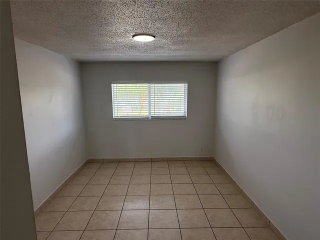 an empty room with white walls and tiles