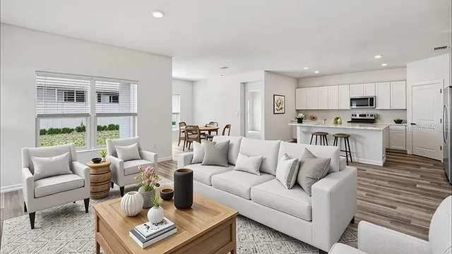 a living room with furniture kitchen and a table