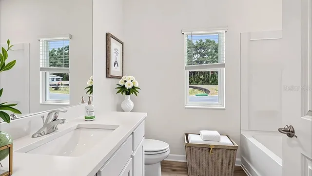 a bathroom with a sink toilet and a mirror