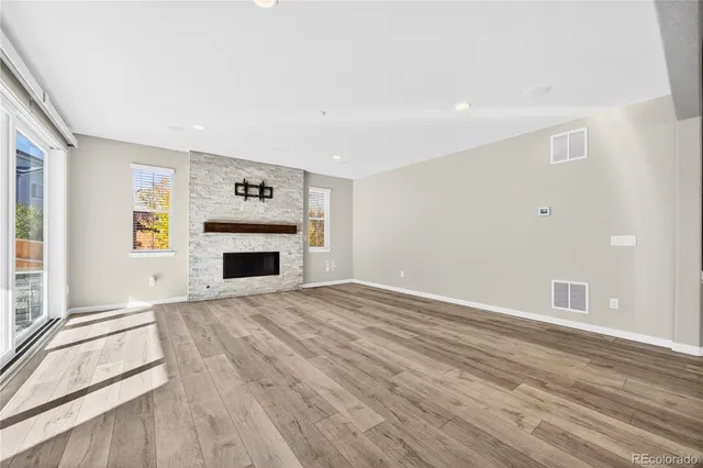 wooden floor fireplace and windows in an empty room