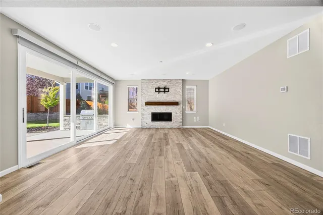 a view of empty room with wooden floor and floor to ceiling window