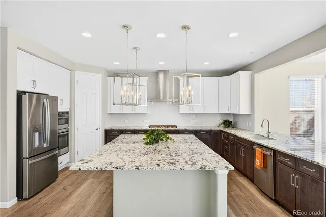a kitchen with a refrigerator a sink and wooden cabinets