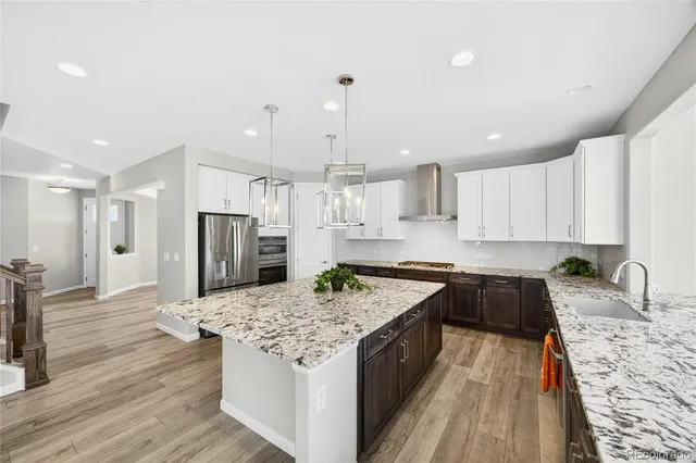 a kitchen with kitchen island granite countertop a sink stove and refrigerator
