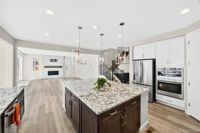 a kitchen with stainless steel appliances granite countertop a kitchen island a stove and a refrigerator