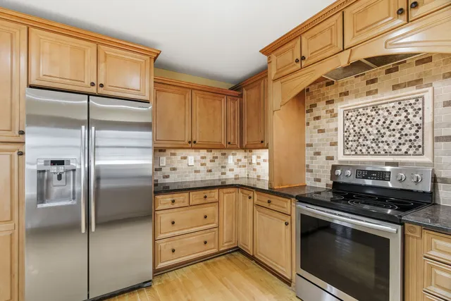 a kitchen with granite countertop stainless steel appliances cabinets and a counter top space