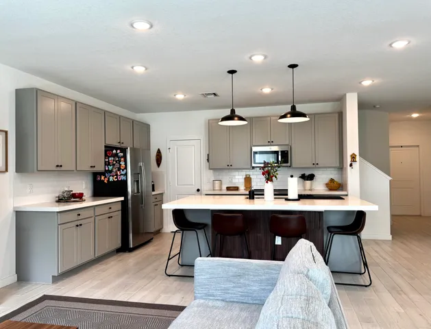 a kitchen with kitchen island stainless steel appliances a sink and cabinets
