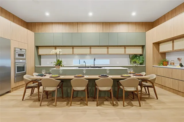 a kitchen with a table chairs sink and cabinets