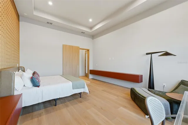 a bedroom with a bed and wooden floor