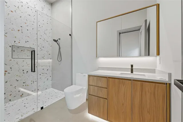 a bathroom with a granite countertop sink a toilet and shower