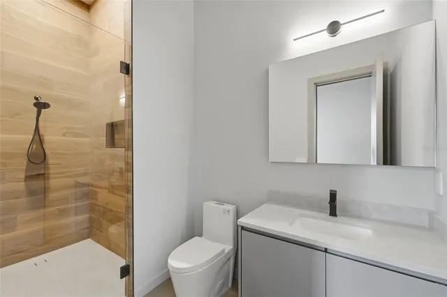 a bathroom with a granite countertop sink toilet and shower