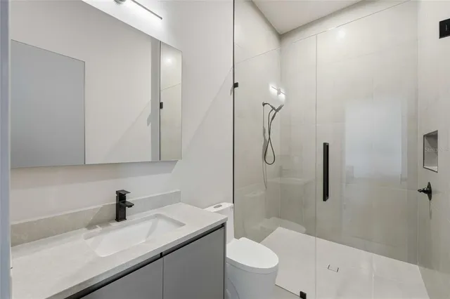 a bathroom with a sink a toilet and shower