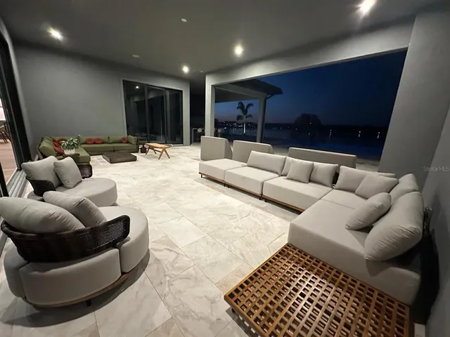 a outdoor space with lots of tables a couch and kitchen view