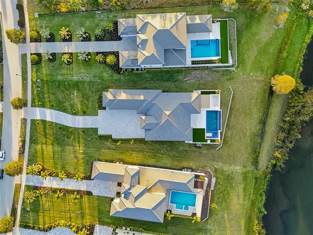 an aerial view of residential houses with outdoor space and street view
